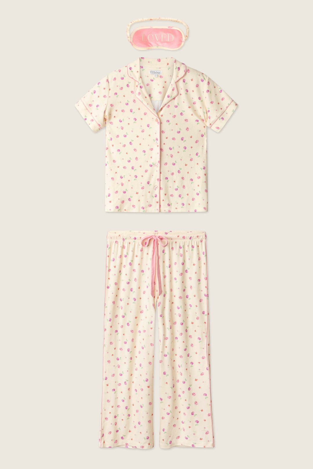 The P.J. Salvage For the Mamas Butter Blooms Cropped 3-Piece PJ Set includes a short-sleeved floral top, matching pants, and a pink “LOVED” sleep mask—offering cozy pointelle comfort for relaxing at home.