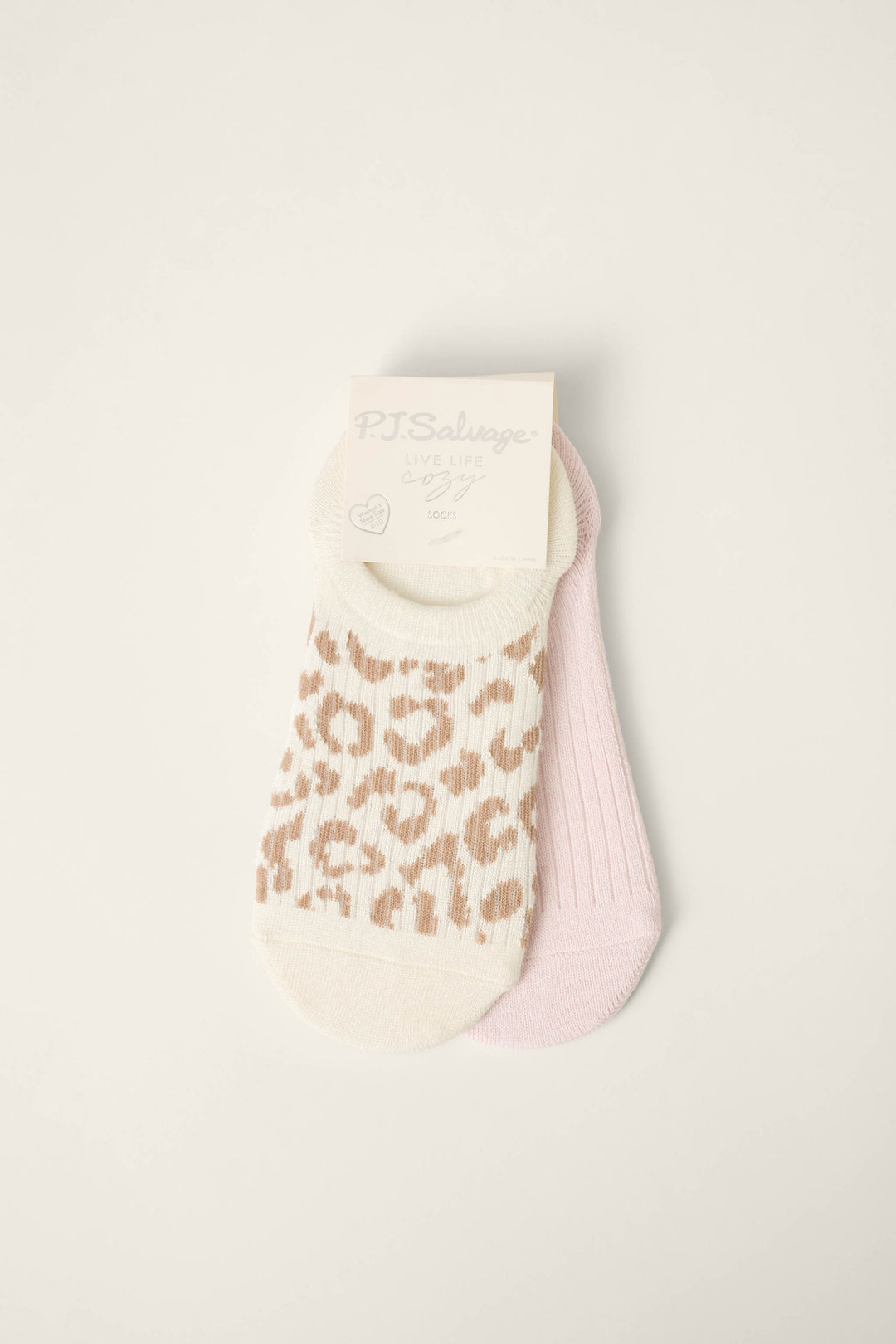 The P.J. Salvage Luxe Leopard Dreams 2-Pack Ankle Socks With Heel Tab includes a beige and white animal print pair and a solid light pink pair, both shown with branded labeling on a plain white background.