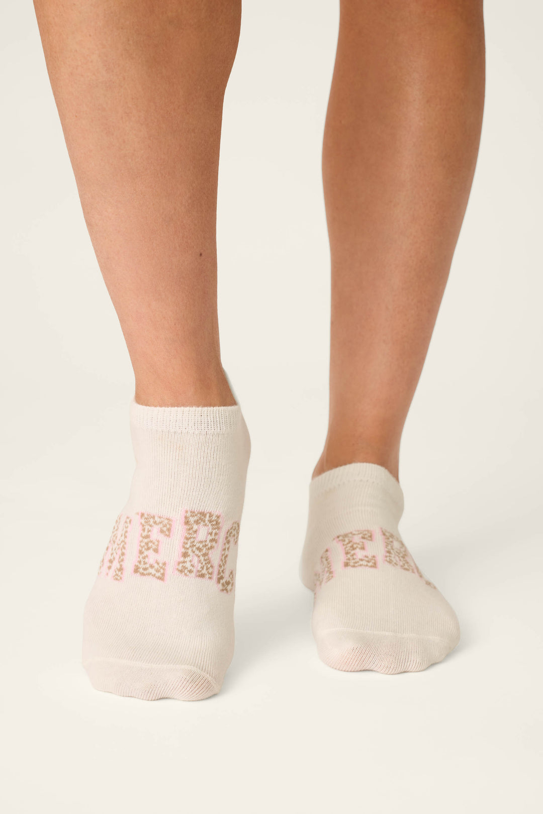 Someone stands on a white background wearing P.J. Salvage's Luxe Leopard Dreams 3-Pack Ankle Socks, which feature chic French-inspired designs and cheerful details.