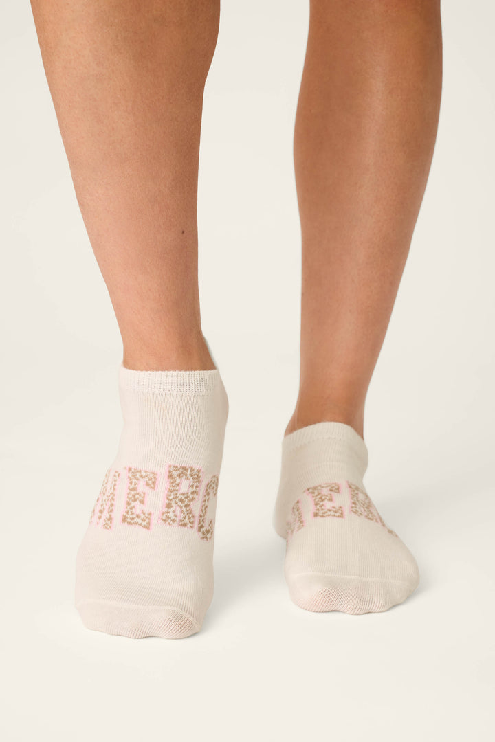 Someone stands on a white background wearing P.J. Salvage's Luxe Leopard Dreams 3-Pack Ankle Socks, which feature chic French-inspired designs and cheerful details.