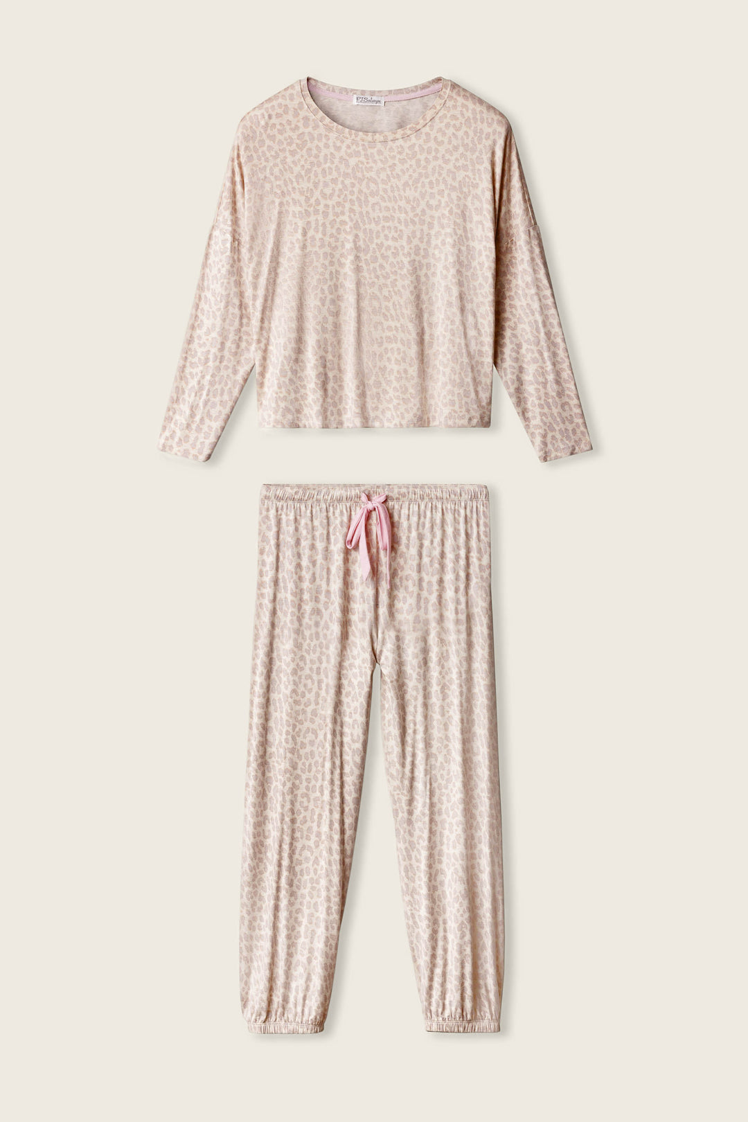 The Luxe Leopard Dreams Lounge Set by P.J. Salvage is a two-piece pajama set in light beige and cream, featuring a long-sleeve top and drawstring pants with elastic cuffs, crafted from soft jersey fabric.