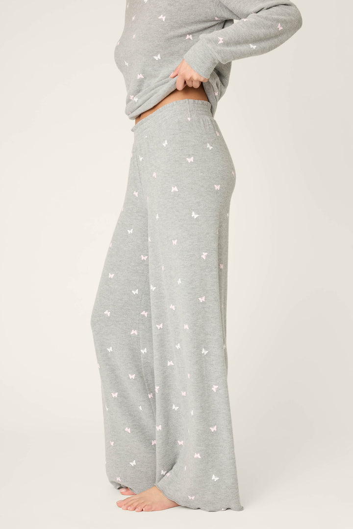 A person stands barefoot, cropped from the shoulders down, wearing P.J. Salvage’s Peachy Mix & Match Butterfly Kisses Open Leg Lounge Pants against a plain light background.