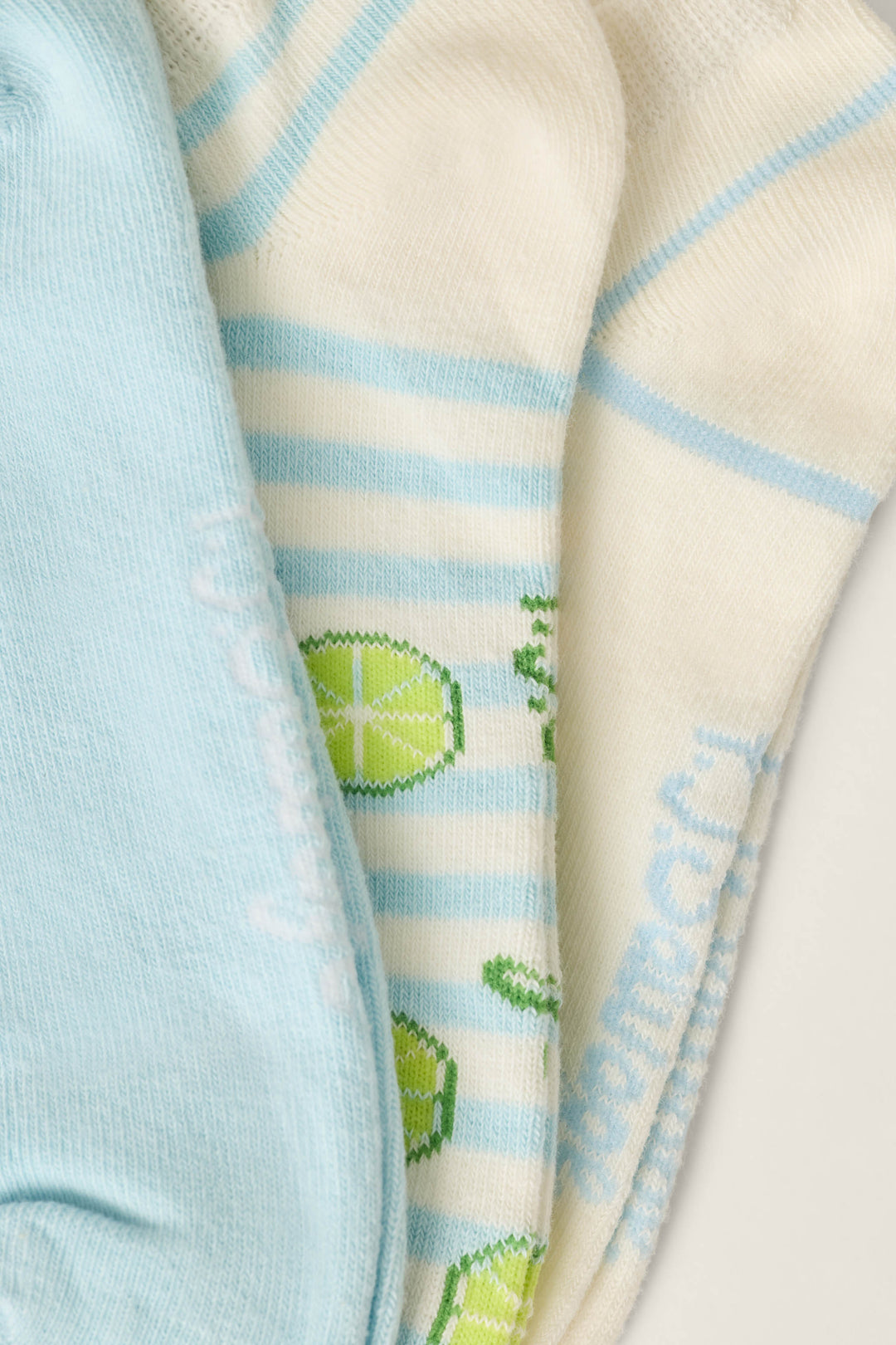The P.J. Salvage Playful Prints Feeling Salty 3-Pack No Show Socks features coastal-inspired designs in light blue, white with blue stripes and lime patterns, and white with blue stripes—combining comfort and style for every step.