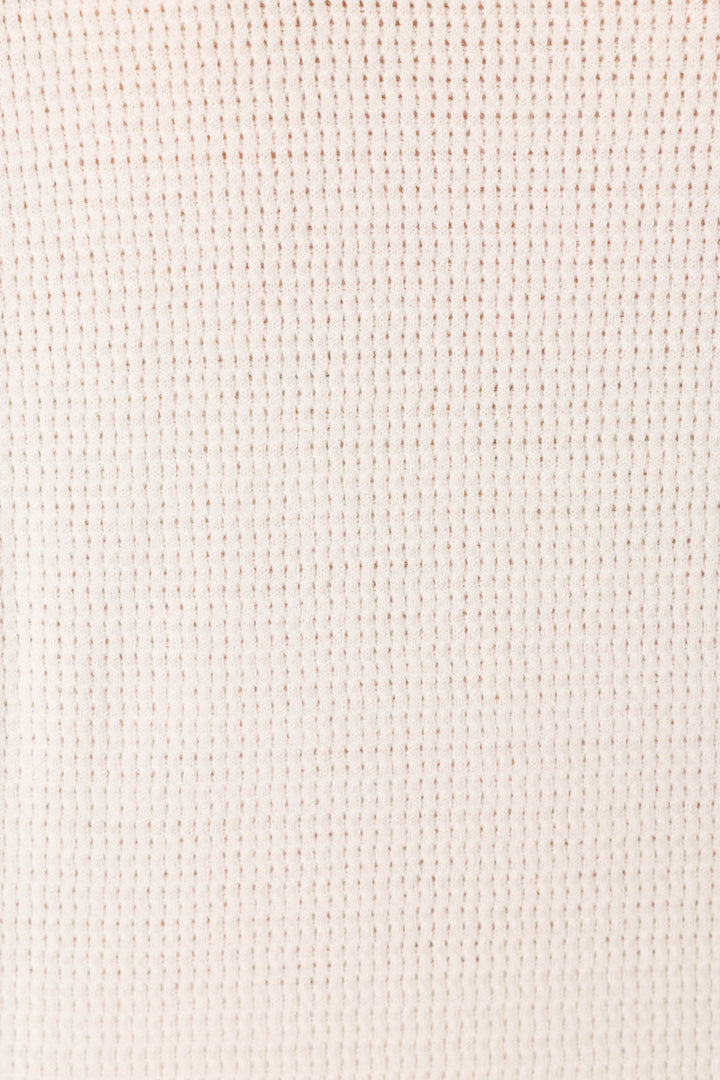 A close-up of the Playful Prints Bon Voyage Pullover Sweater by P.J. Salvage, showcasing its ivory waffle-knit fabric and soft, grid-like textured pattern.