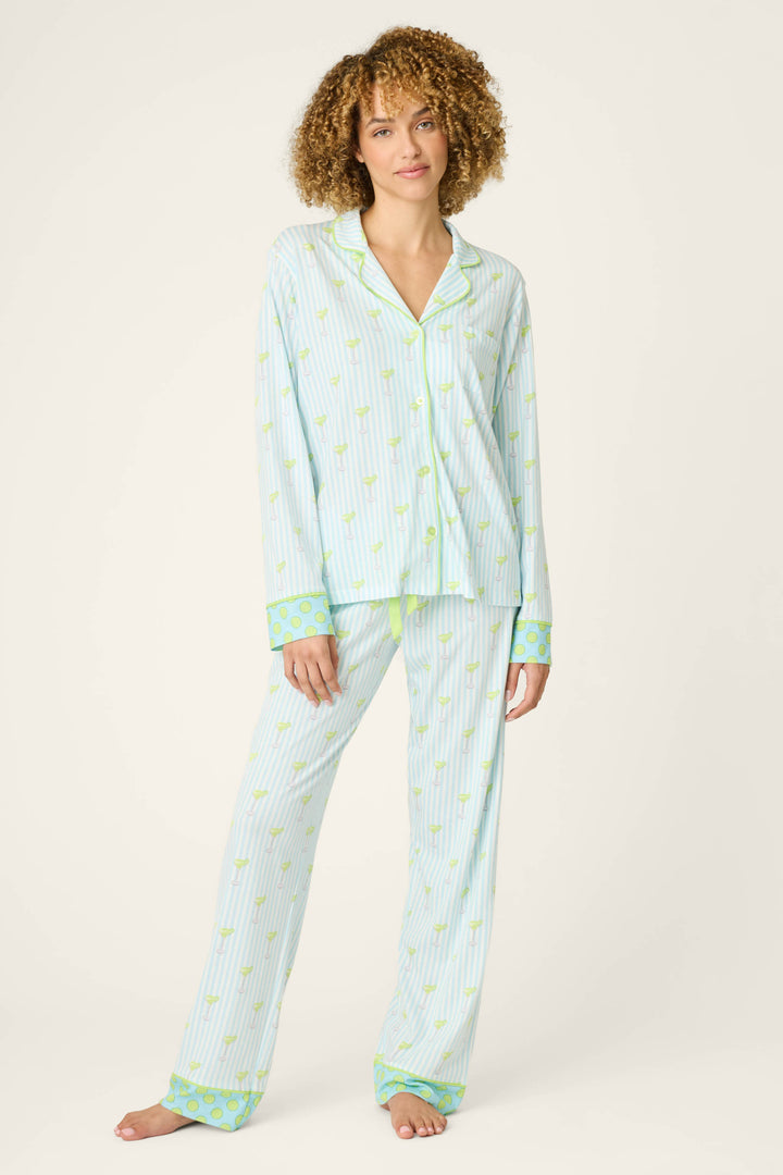 A person wears the P.J. Salvage Playful Prints Salty Cadillac Striped Long PJ Set, featuring a cotton-modal jersey with lemon print, a long-sleeve button-up top and pants, and green cuffs with a blue-green pattern for cocktail-inspired style.