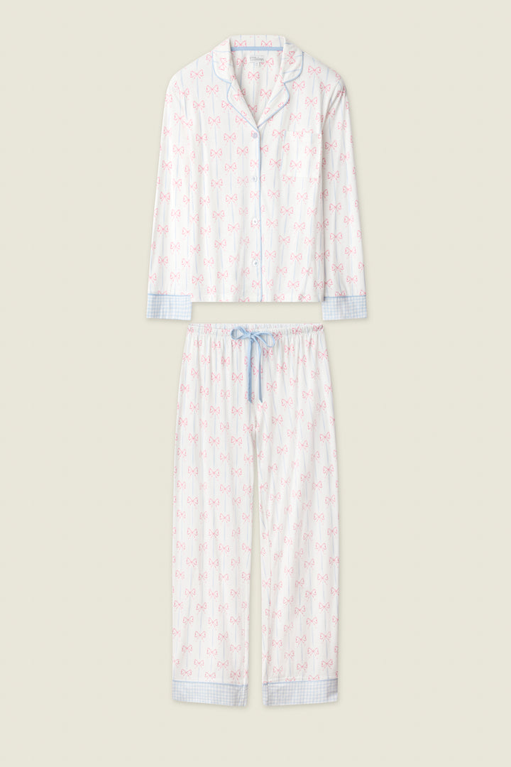 The Playful Prints All Wrapped Up Long PJ Set by P.J. Salvage features a white button-front shirt and matching pants with pink bow prints, blue plaid trim, and a coordinating blue drawstring waist.