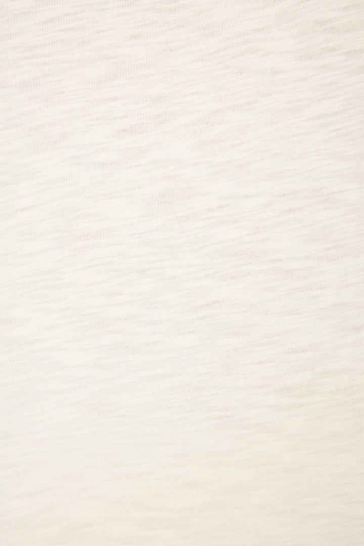 A close-up of the Playful Prints Bon Voyage Graphic Tee by P.J. Salvage shows its light beige cotton-modal jersey with a subtle wavy texture—smooth, uniform, and perfect for a relaxed, minimal look ideal for coastal escapes.