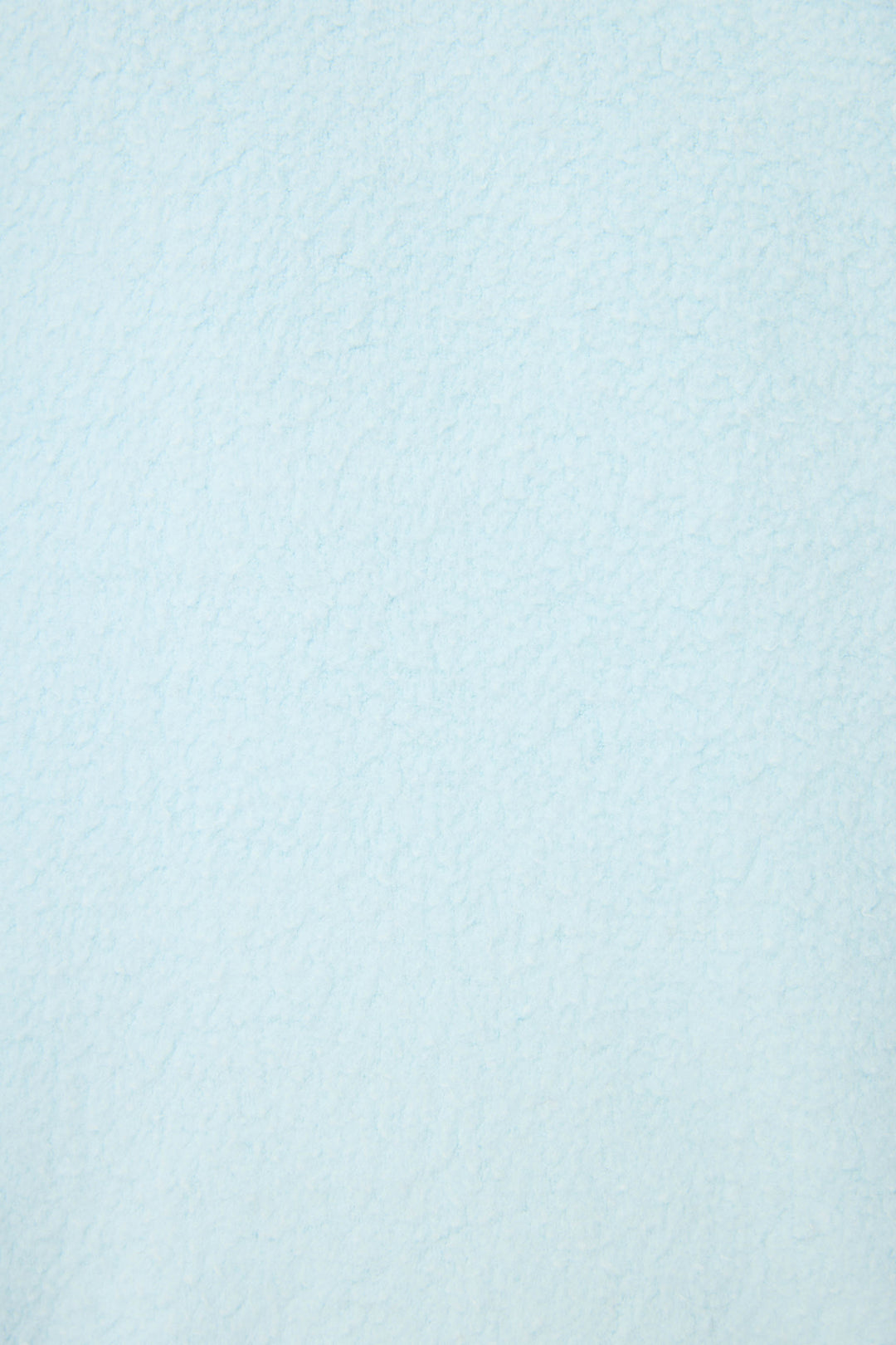 A close-up of the Pupcation Palms Vacay Pullover Sweater by P.J. Salvage, featuring a textured, light blue surface with cloud-like shading and a slightly uneven finish.