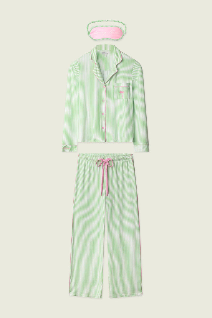 The P.J. Salvage Pupcation Palms Kiwi Stripe 3-Piece PJ Set features a light green and white striped long-sleeve button-up top, drawstring pants, and an eye mask with pink accents for a cozy, coordinated look.