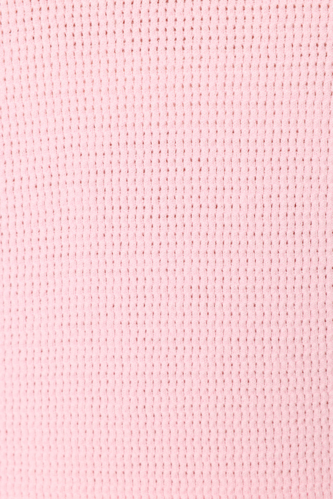 Close-up of the Roses Are Pink Rosé All Day Snuggle Sweater by P.J. Salvage, highlighting its pink waffle knit fabric with a grid-like textured pattern formed by small, evenly spaced rectangular indentations.
