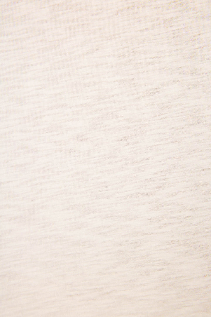 A close-up of the P.J. Salvage Roses Are Pink Heart Bloom Graphic T-Shirt shows its light beige fabric with a soft feel, subtle horizontal texture, and faint irregular lines evenly lit on the surface.