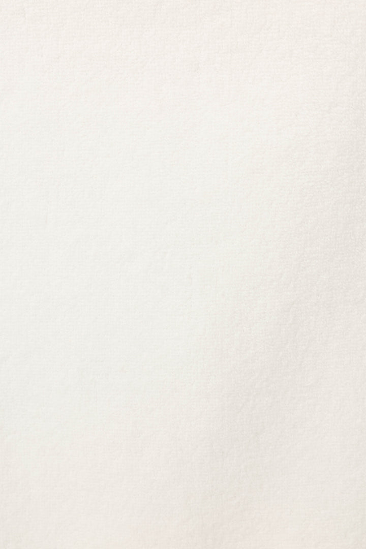 A close-up of the Playful Terry Happy Hour Robe by P.J. Salvage shows its off-white, textured terry fabric with subtle shading and fine grain.