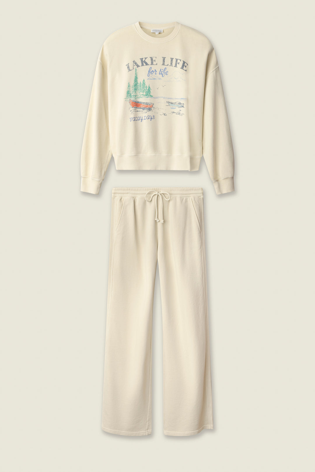 The Washed Away Lake Life For Life Long Lounge Set by P.J. Salvage includes a cream French terry crewneck with a lake-inspired graphic and matching wide-leg drawstring sweatpants for cozy comfort.