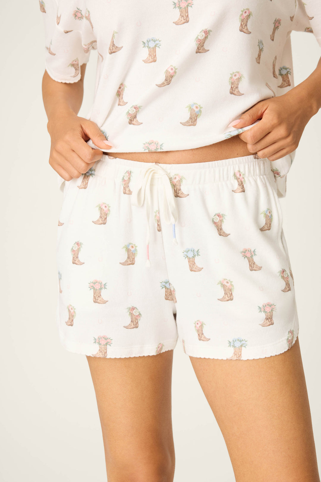 A person wears P.J. Salvage Western Blooms Boot Bouquet Shorts, shown from mid-torso to mid-thigh.