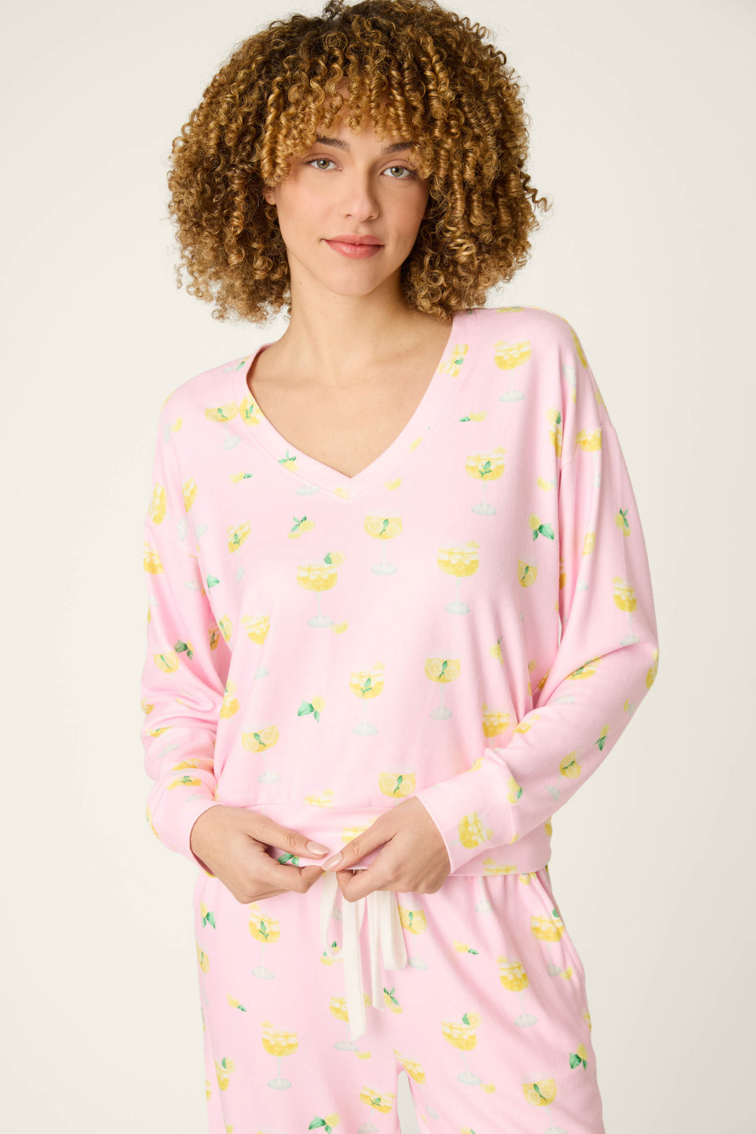 Light pink fabric patterned with a playful citrus print; smooth texture and soft appearance.
