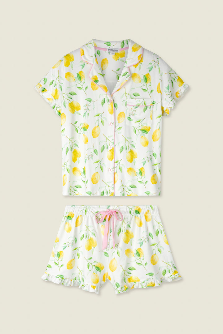 White fabric with yellow lemon and green leaf print, accented by pink trim and a pink drawstring.