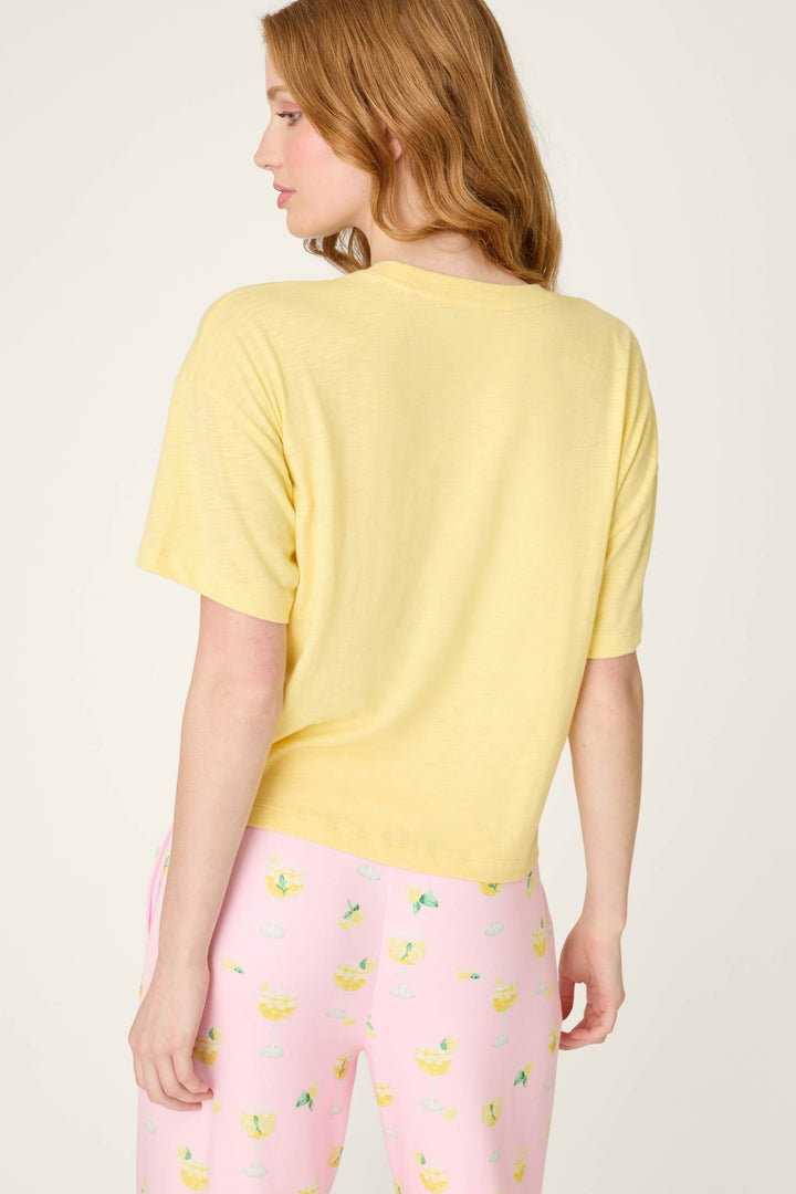 Pink fabric with a playful citrus drink pattern on a light background. T-shirt fabric has a colorful Limoncello graphic print.