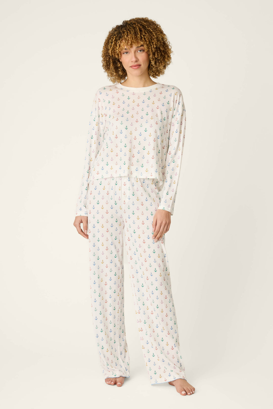 White fabric with a pattern of small, multicolored anchors scattered across the surface.