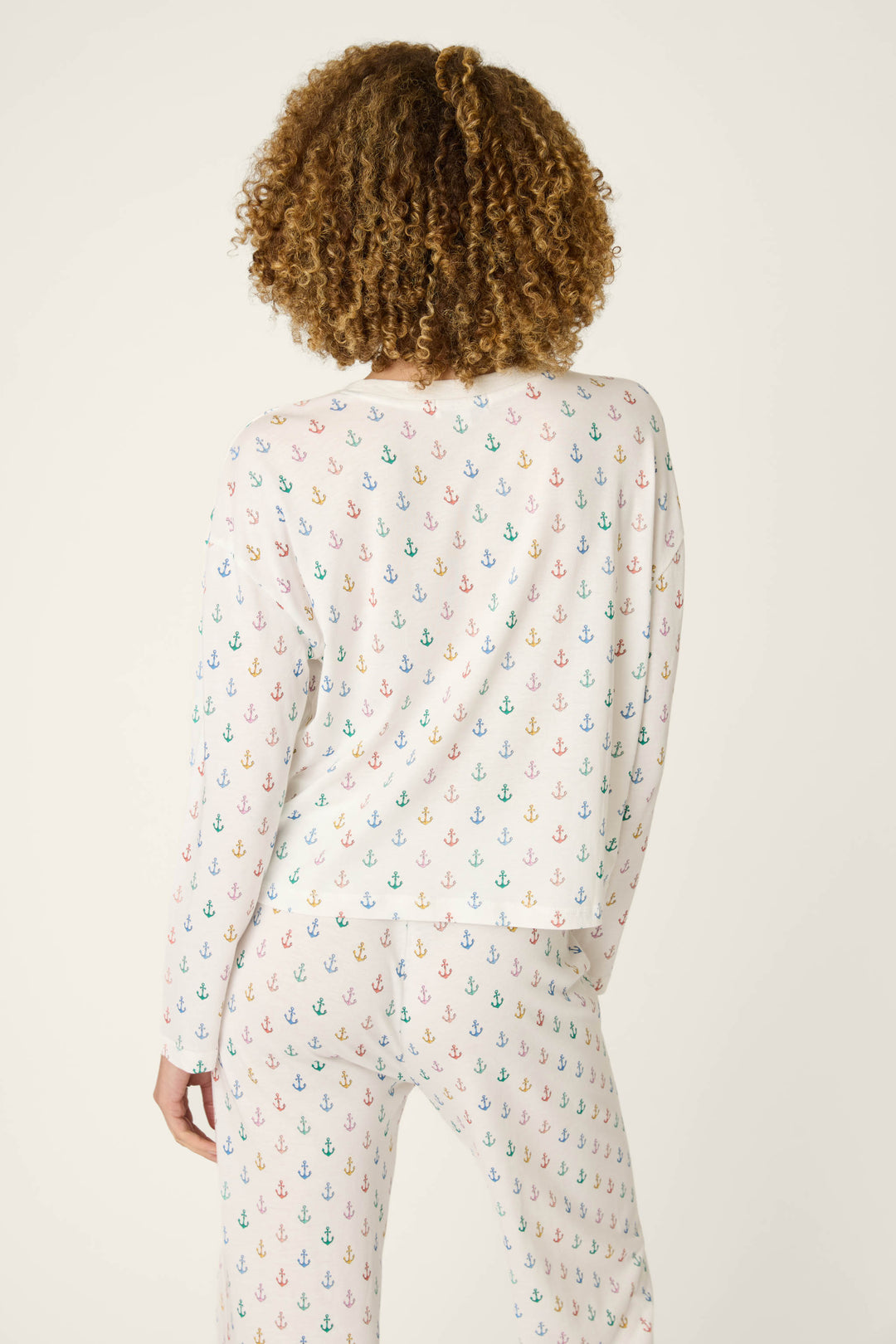White fabric featuring a colorful all-over anchor pattern; smooth texture with a vibrant, playful design.