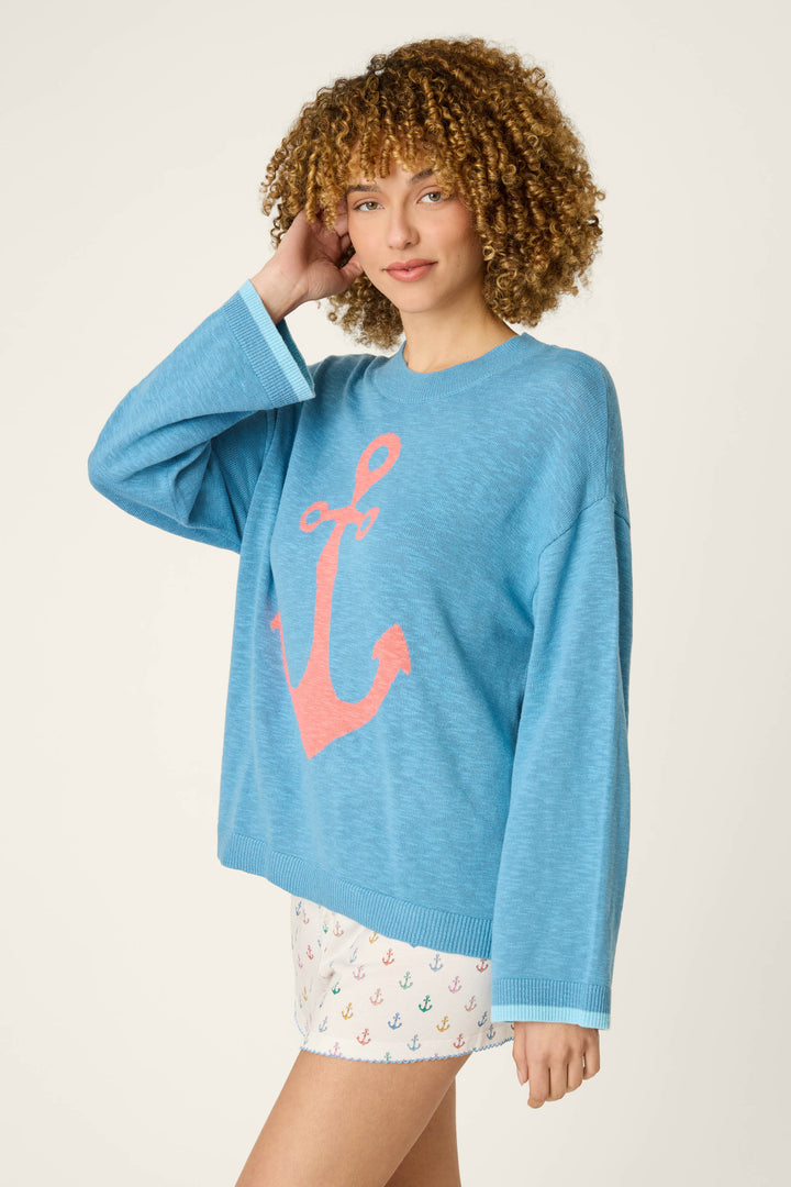 Loose blue fabric with a large pink anchor and white fabric featuring a multicolored anchor pattern.
