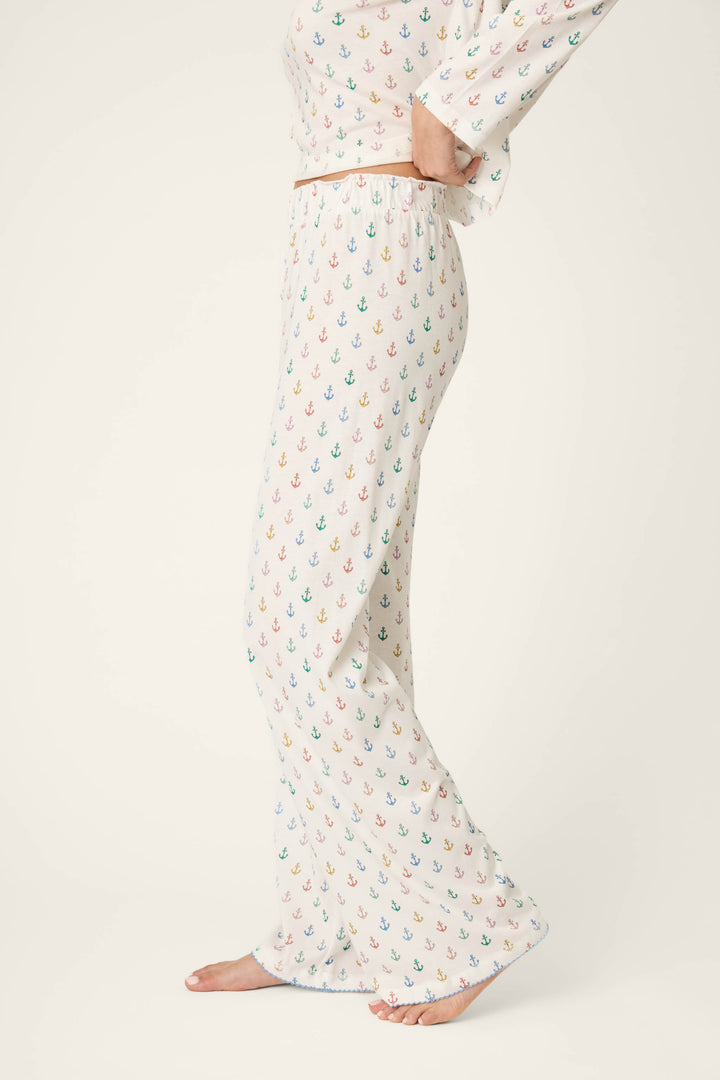 A multicolored anchor pattern decorates a relaxed, soft fabric, with vibrant hues standing out against the textile’s background.