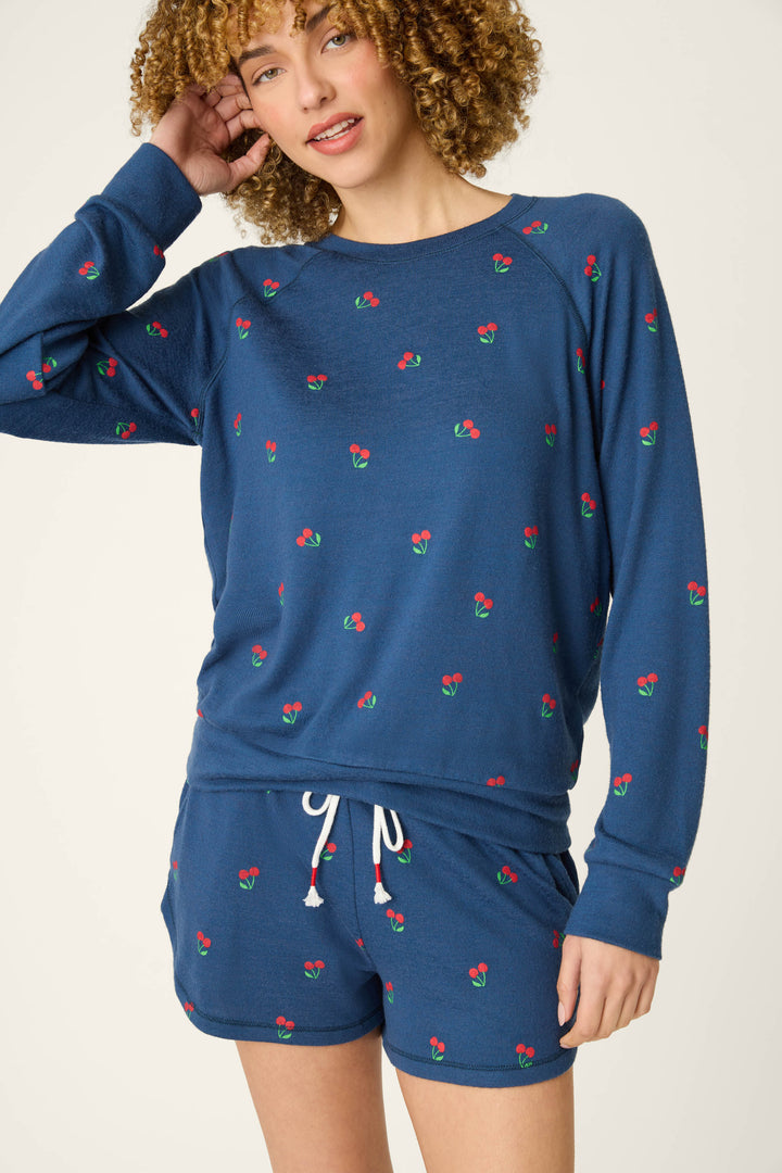 True navy fabric with a small cherry print pattern, accented by a white drawstring and star spangled details.