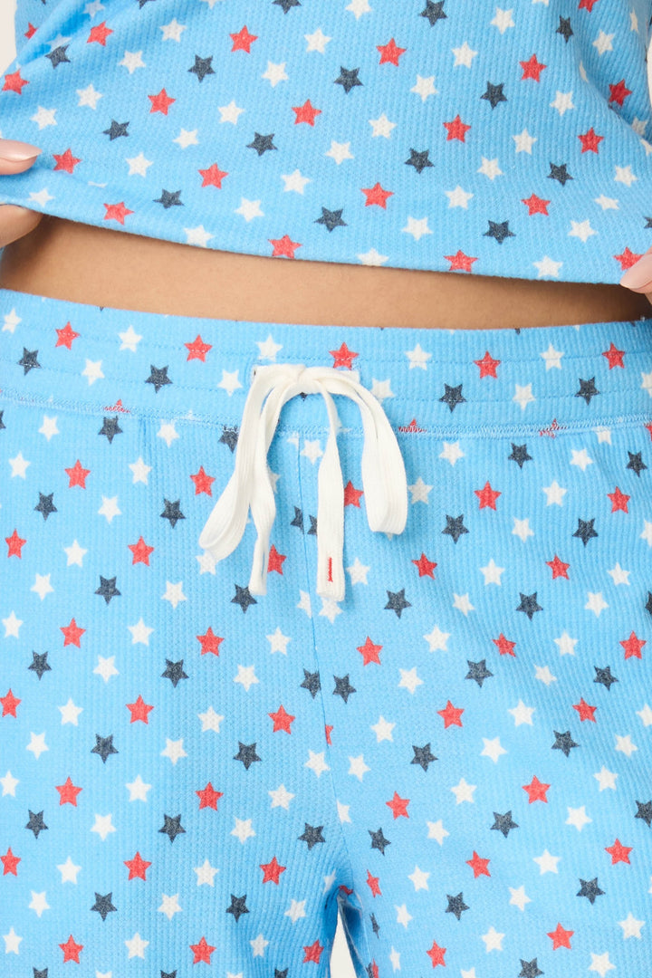 Fabric features a bay blue background with white, red, and dark blue star print and a white drawstring accent.