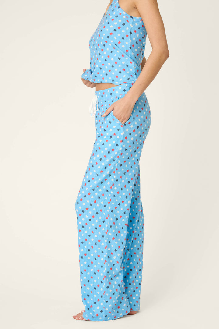 Blue fabric with a red and white star pattern, featuring a soft texture against a plain off-white background.