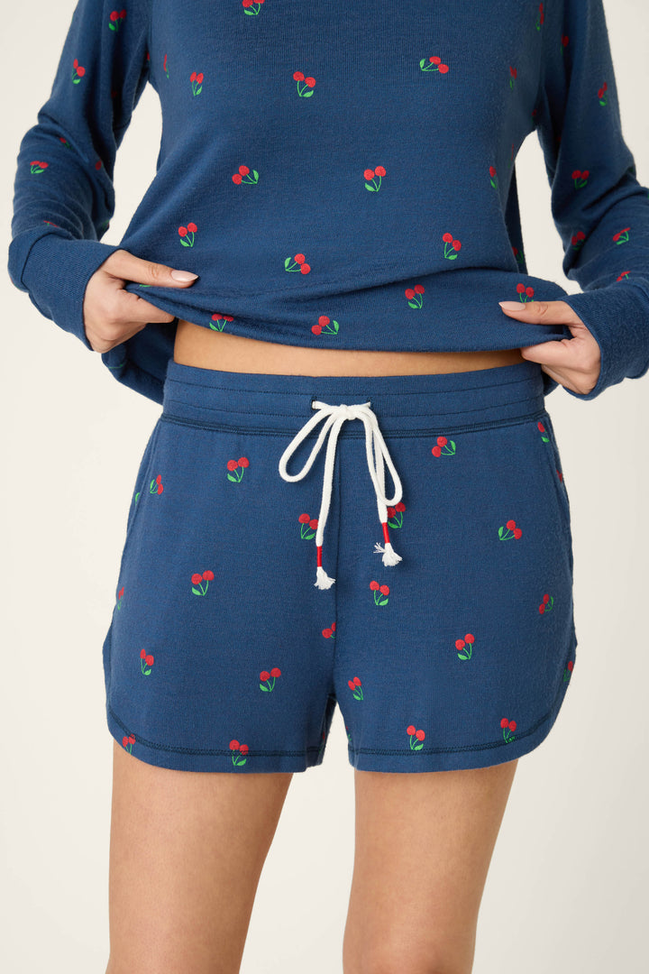 True navy blue fabric with a scattered red cherry print, soft texture, and white drawstring accent.