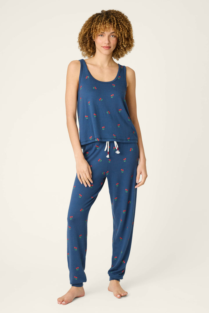Blue fabric patterned with small red cherries and finished with a white drawstring; smooth, lightweight texture.