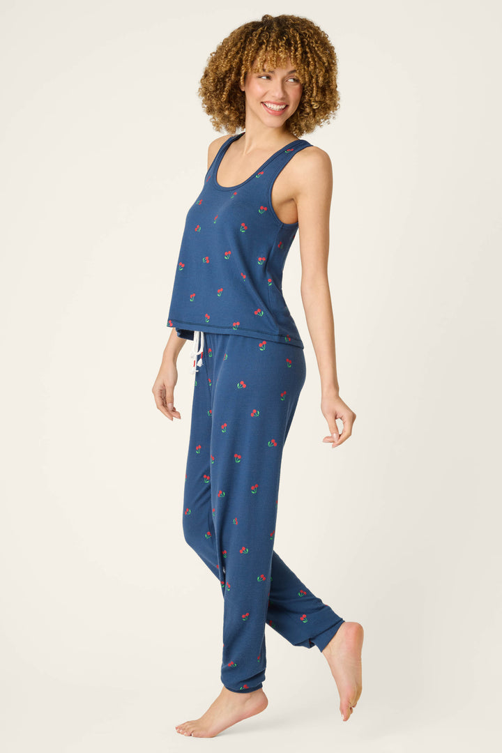 Blue fabric with a small red and green cherry pattern on a plain, light background.