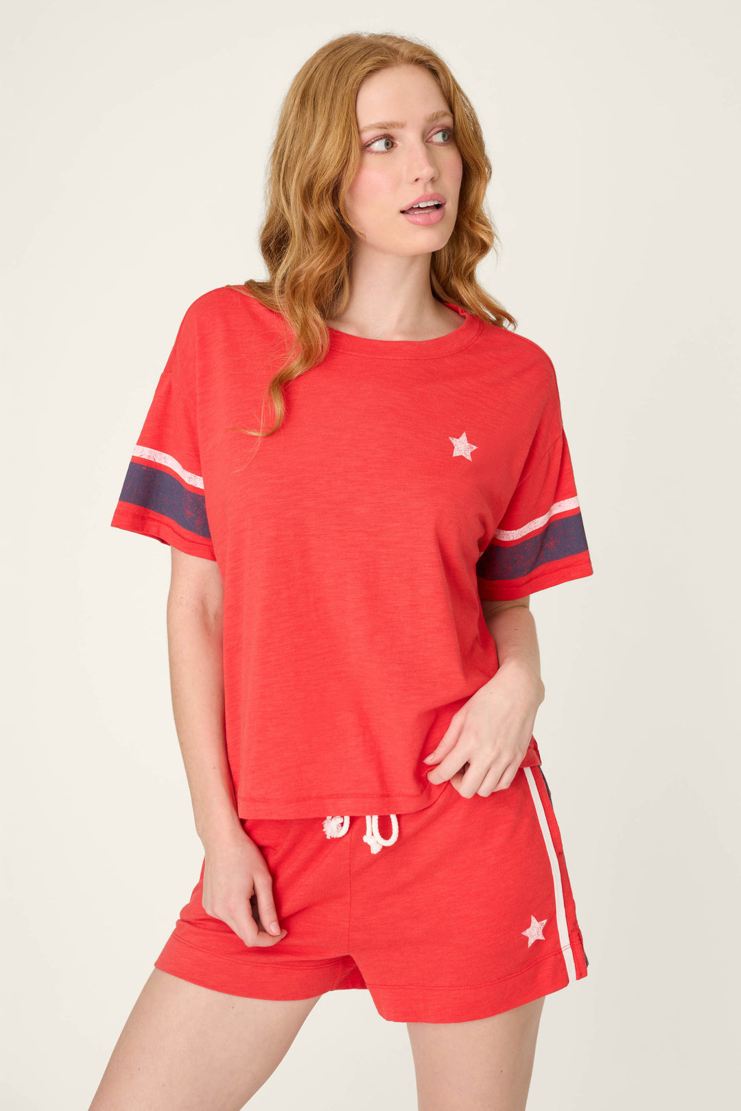 True scarlet red fabric with small white star accents, navy and white sleeve stripes, and white side stripes on matching red material.