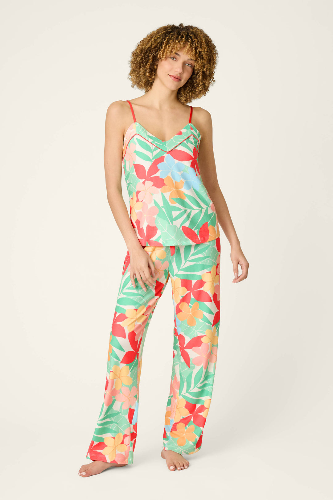 Tropical print fabric with red accents, featuring a vibrant and playful pattern in sunset-inspired hues.