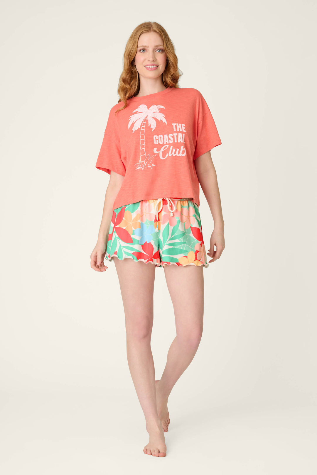 Coral fabric with "The Coastal Club" text and a white palm tree graphic, paired with a colorful floral print and drawstring.