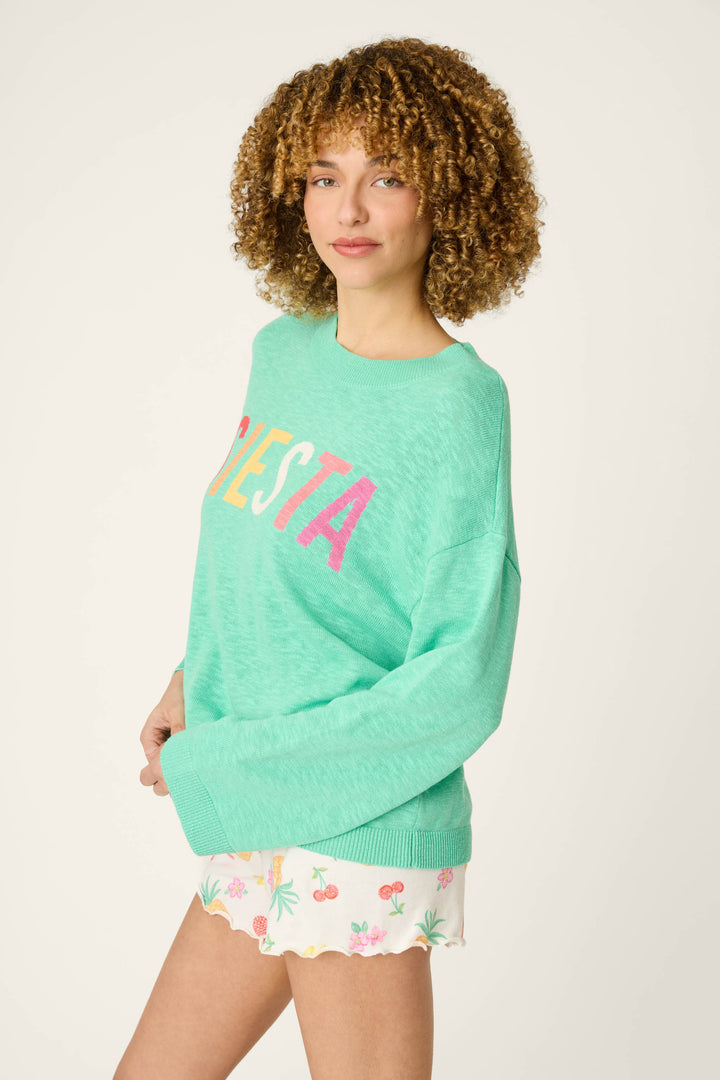Mint green fabric with colorful "FIESTA" lettering, paired with white material adorned in soft pastel floral patterns.