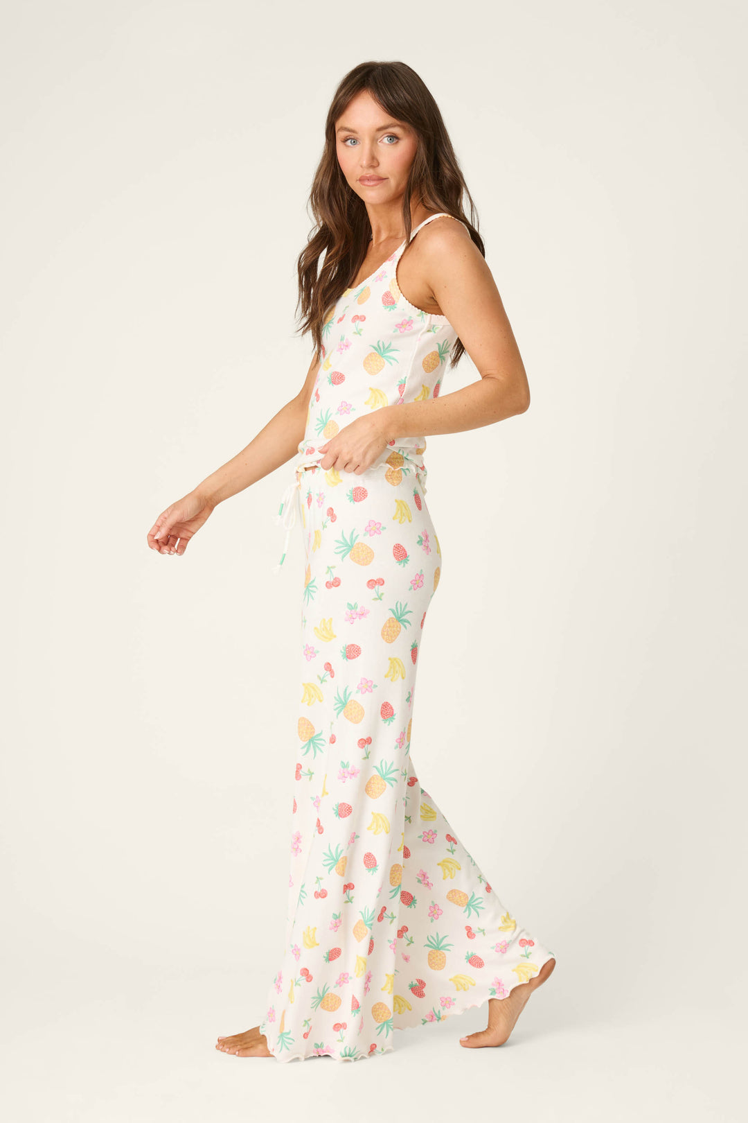 White fabric featuring a colorful fruit print pattern and smooth texture, accented by a drawstring detail.