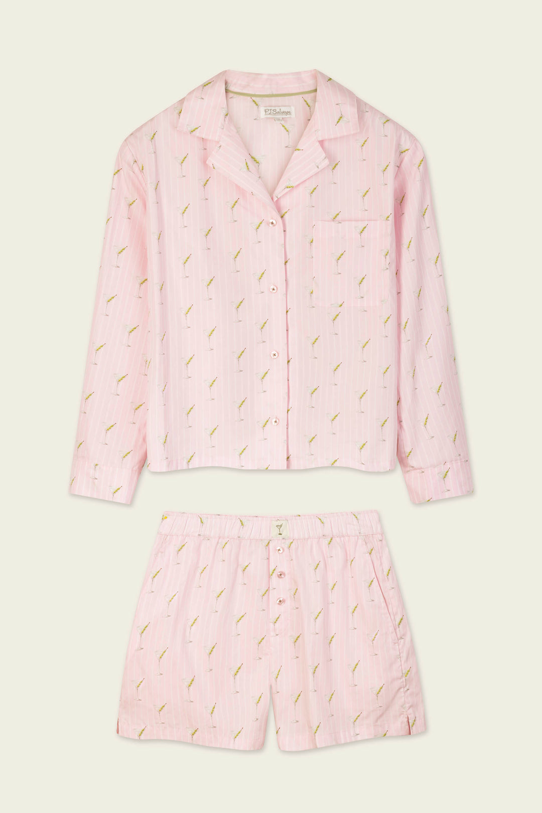 The Afterparty Poplin Martini Print Long Sleeve & Shorts PJ Set by P.J. Salvage features a light pink button-up long sleeve top and matching shorts with a subtle pattern of small green and yellow embroidered plants, laid flat on a cream background.