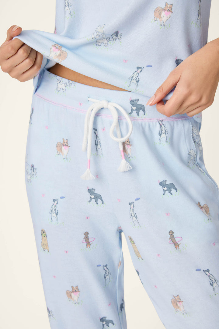 Model wears the P.J. Salvage Bark Park Fetch & Frolic Long PJ Set, featuring playful dog breeds on peachy-soft jersey fabric with jogger-style pants and a comfy waistband.