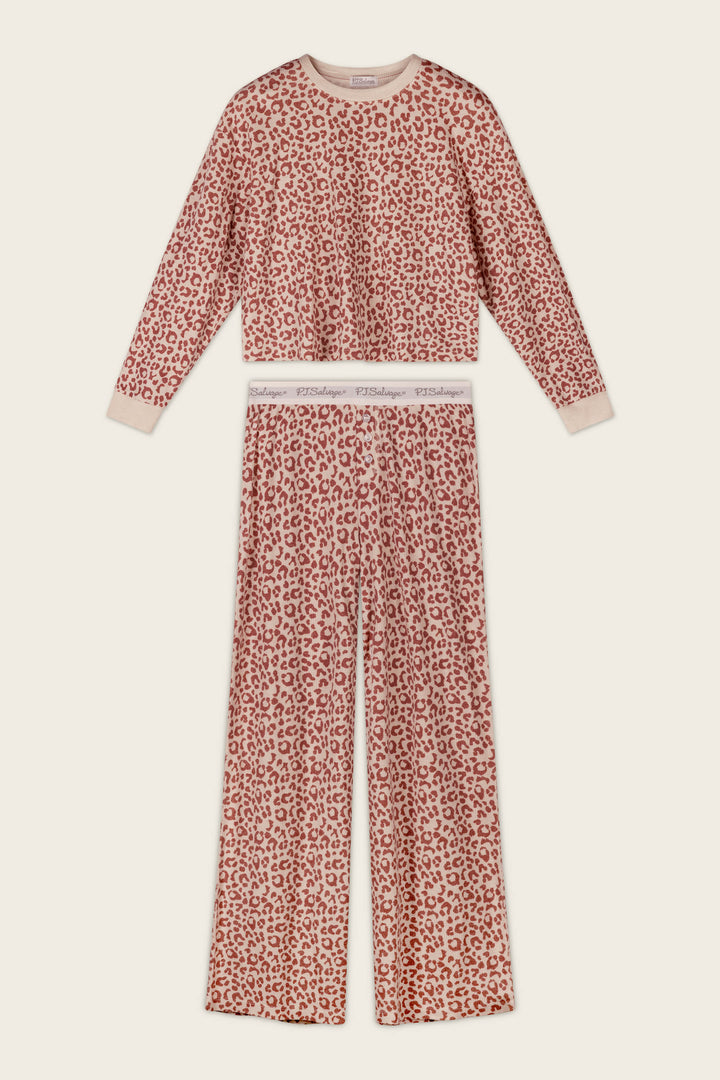 The P.J. Salvage Boyfriend Boxer Leopard Print Long Sleeve PJ Set features a pink and beige leopard print, including a long-sleeve top and coordinating wide-leg pants with a branded elastic waistband, displayed laid flat on a light background.