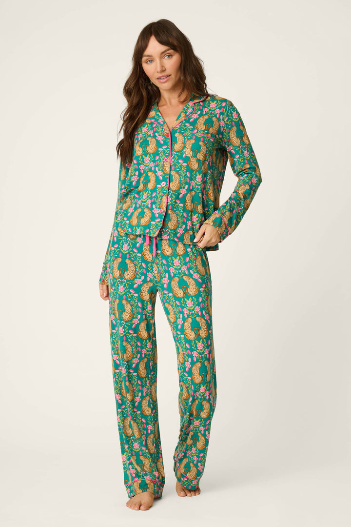 A woman wearing the P.J. Salvage Cheetah Bonita Dreams Cheetah Print Long Sleeve PJ Set stands barefoot against a plain light background.