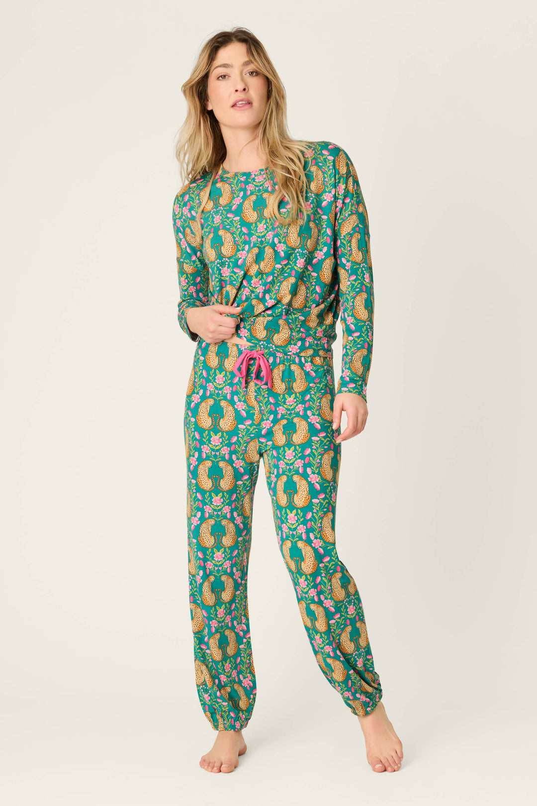 A person stands barefoot wearing the P.J. Salvage Cheetah Bonita Dreams Cheetah Print Pajama Joggers, featuring a bold cheetah print pattern, long jogger-style pants, and a comfortable fit.