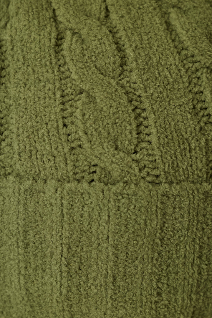 Close-up of the Cozy Chenille Cable Knit Olivine Beanie with Pompom by P.J. Salvage, showcasing its textured green cable knit pattern and vertical ribbing.