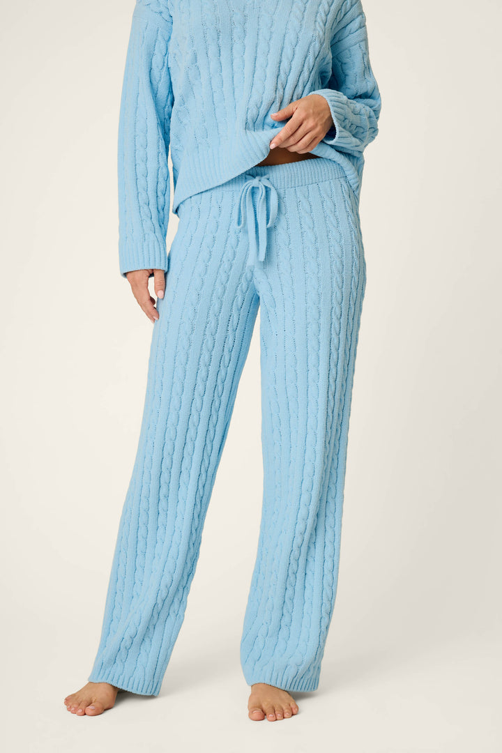 A person wearing the P.J. Salvage Cozy Chenille Cable Knit Cloud Blue Lounge Pants, styled with long sleeves and a drawstring waist, stands barefoot against a plain background.