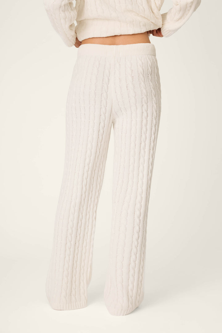 Model wearing the Cozy Chenille Cable Knit Ivory Lounge Pants by P.J. Salvage, shown from the back against a plain, light background, paired with a matching sweater.