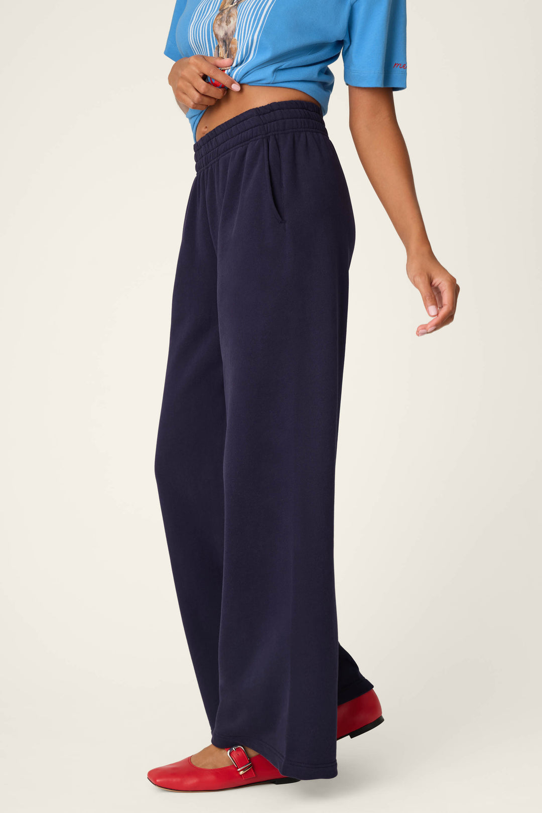 A person wearing the P.J. Salvage C'est La Vie Blue Ink BFF Lounge Pants, a blue cropped T-shirt, and red shoes is posing against a light background. Only the lower half of their face and body is visible.