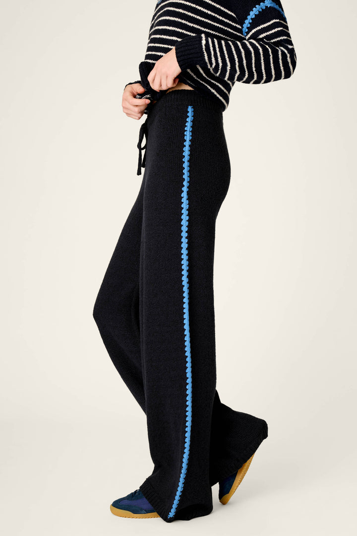Wearing the P.J. Salvage C'est La Vie Suki Jogger Pants, paired with a matching striped sweater featuring blue accents and dark sneakers, the person stands against a plain light background. Only their body is visible, not their face.
