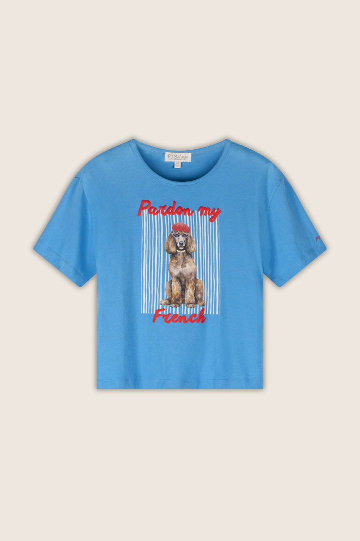 A light blue short-sleeve t-shirt with a graphic of a French Poodle wearing a red bow, framed by vertical white stripes, with the red text 'Pardon my French' on a light beige background.