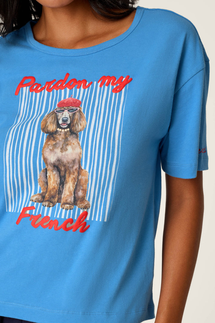 A woman wears the C'est La Vie "Pardon My French" Graphic T-Shirt by P.J. Salvage, which features a dog in a red beret and the words "Pardon my French" over a white and blue striped background.