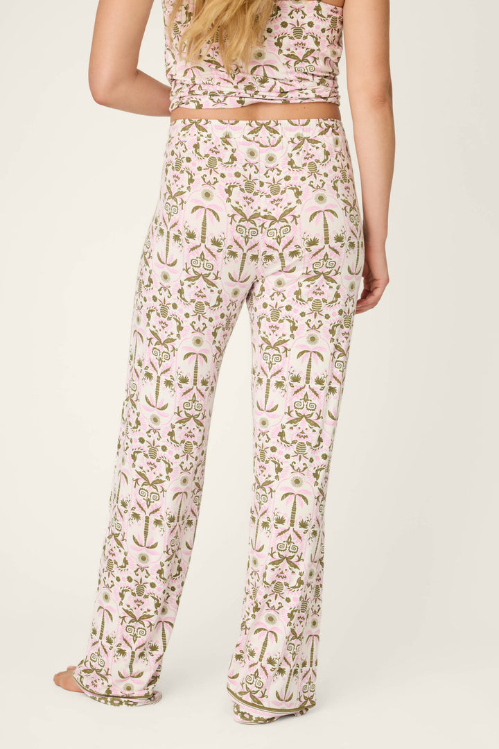 A person with long blonde hair, seen from the back, wears P.J. Salvage Déjà Vu Dreams Tiki Time Open Leg Pants—a relaxed, comfortable floral and palm tree print outfit with a matching sleeveless top.