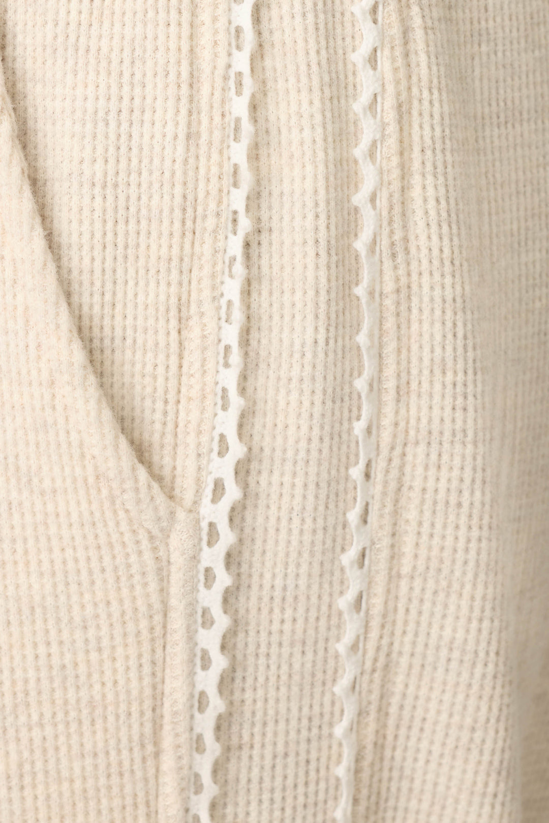 Close-up of the Weekday Waffles Oatmeal Lounge Pants by P.J. Salvage, featuring beige ribbed fabric with a decorative white lace trim running vertically alongside a seam or pocket.
